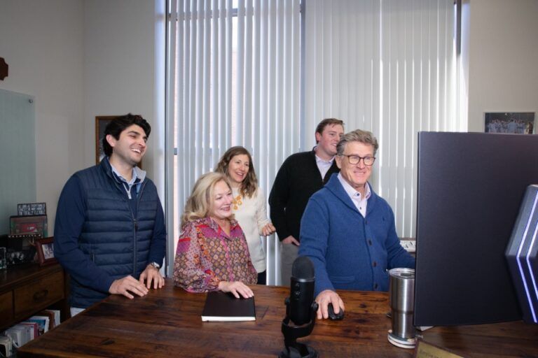 Michael in front of the computer with the team around him